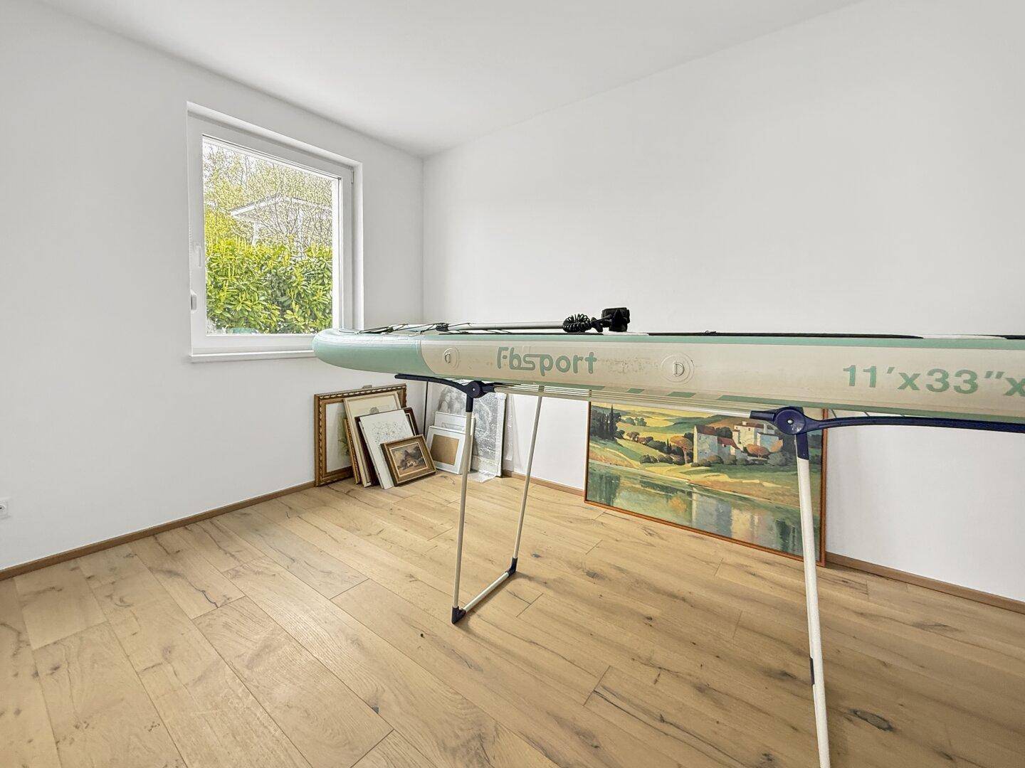 Raum mit Holzboden und Fenster, derzeit als Abstellraum genutzt.