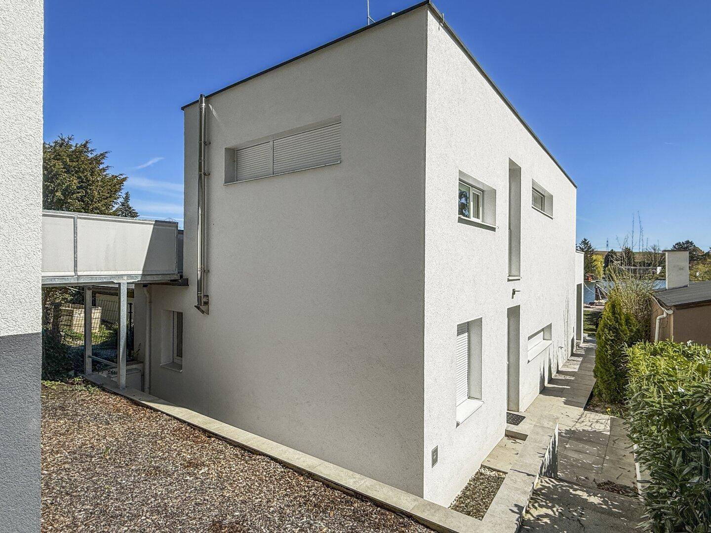 Moderne Architektur des Hauses mit weißer Fassade und klaren Linien.