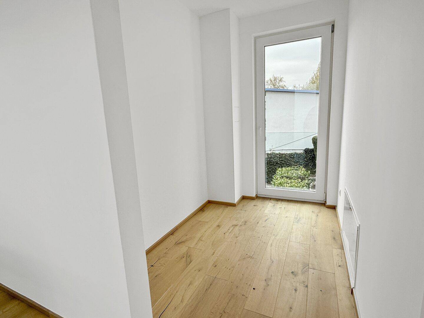 Kleiner Raum mit Holzboden und Fenster, ideal als Abstellraum oder Büro.