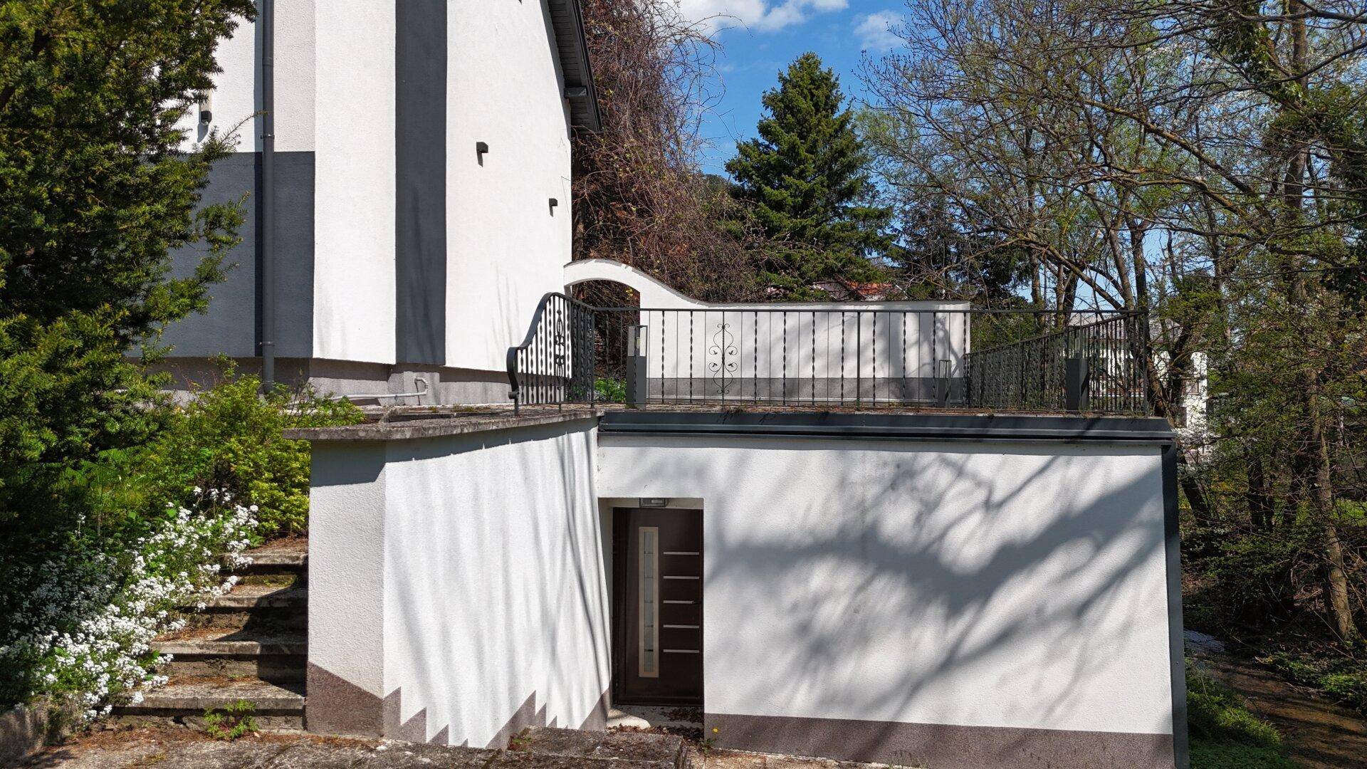 Eingang zum Untergeschoss mit Außentreppe und kleiner Terrasse darüber.