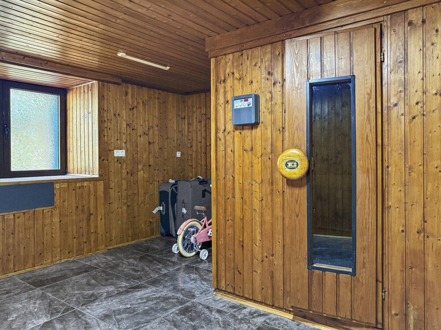 Saunabereich mit holzvertäfelten Wänden und Fenster.