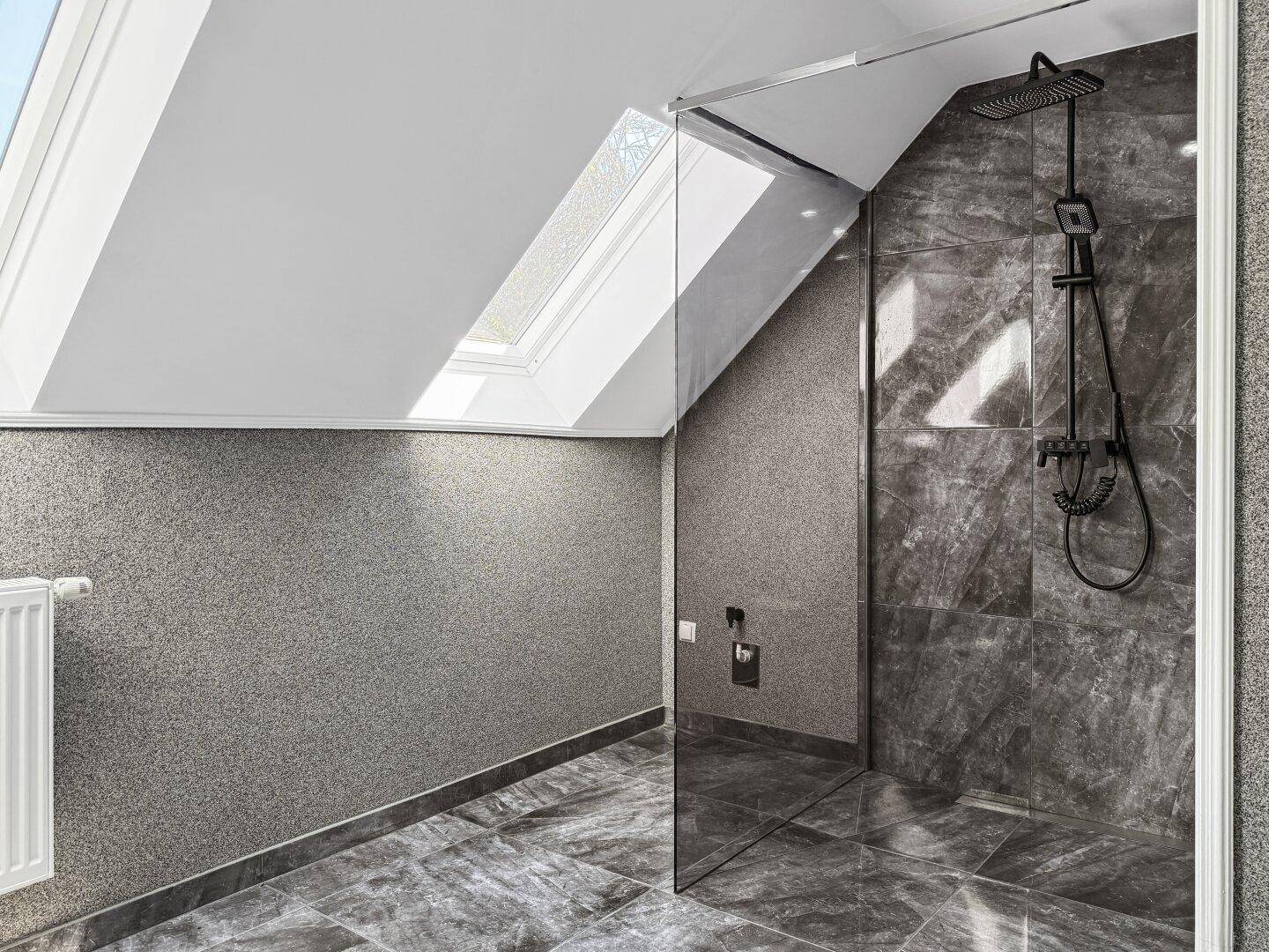Modernes Badezimmer im Dachgeschoss mit großer begehbarer Dusche und Dachfenstern.