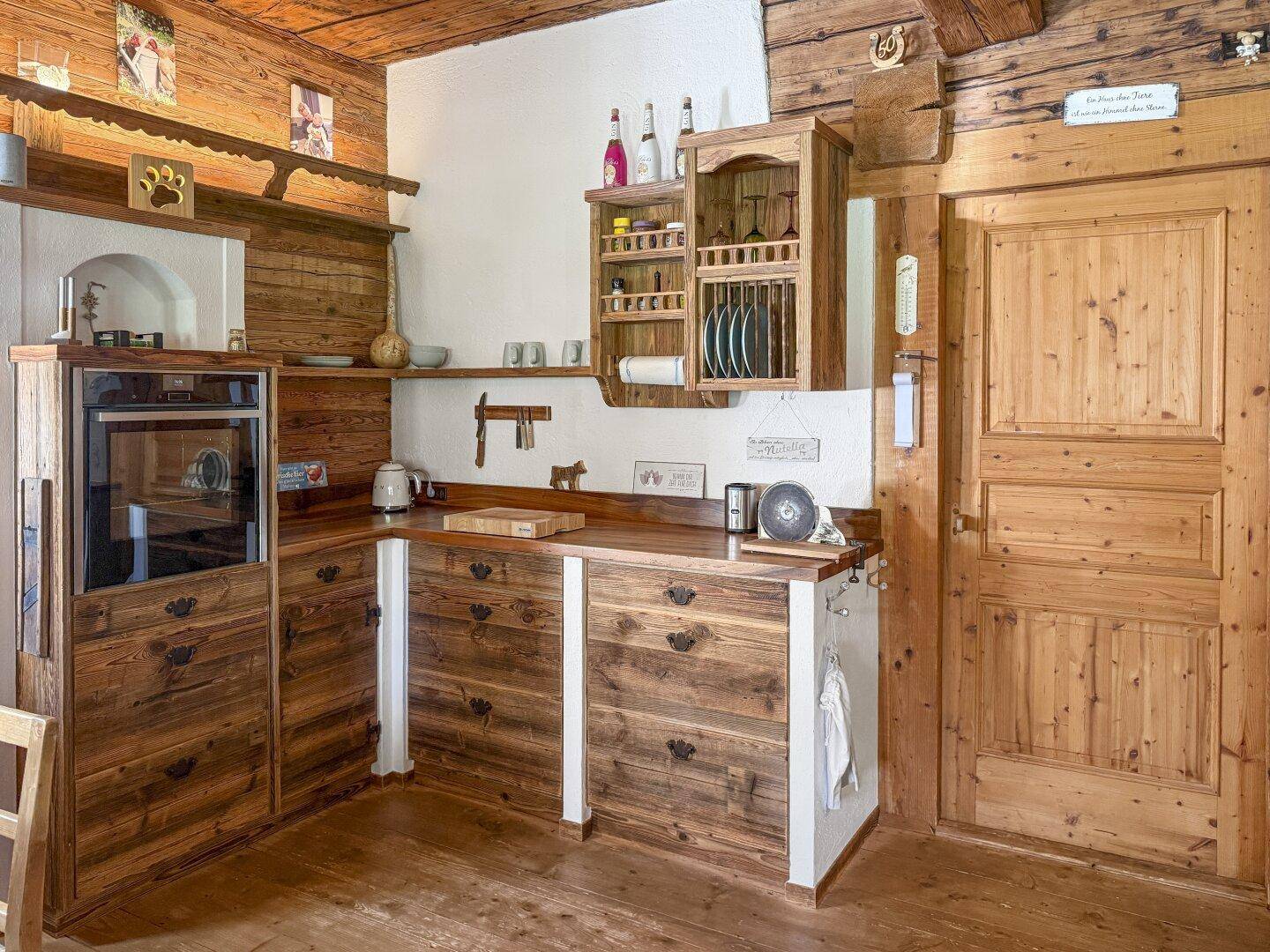 Rustikale Holzküche mit Einbaugeräten und traditionellen Holzschränken, passend zum Chalet-Stil.