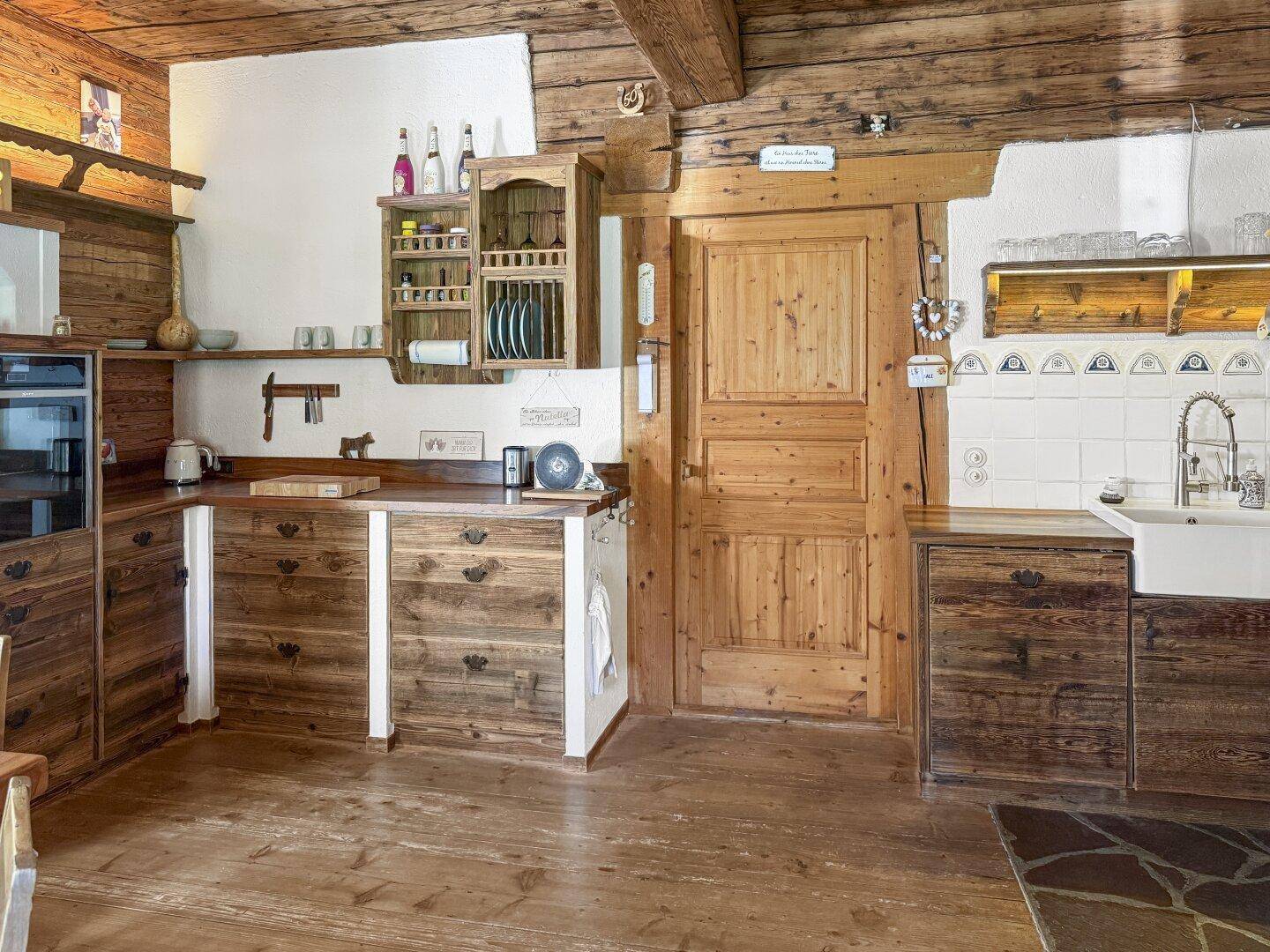 Rustikale Holzküche mit integrierten Geräten und traditionellen Details, passend zum Gesamtstil.