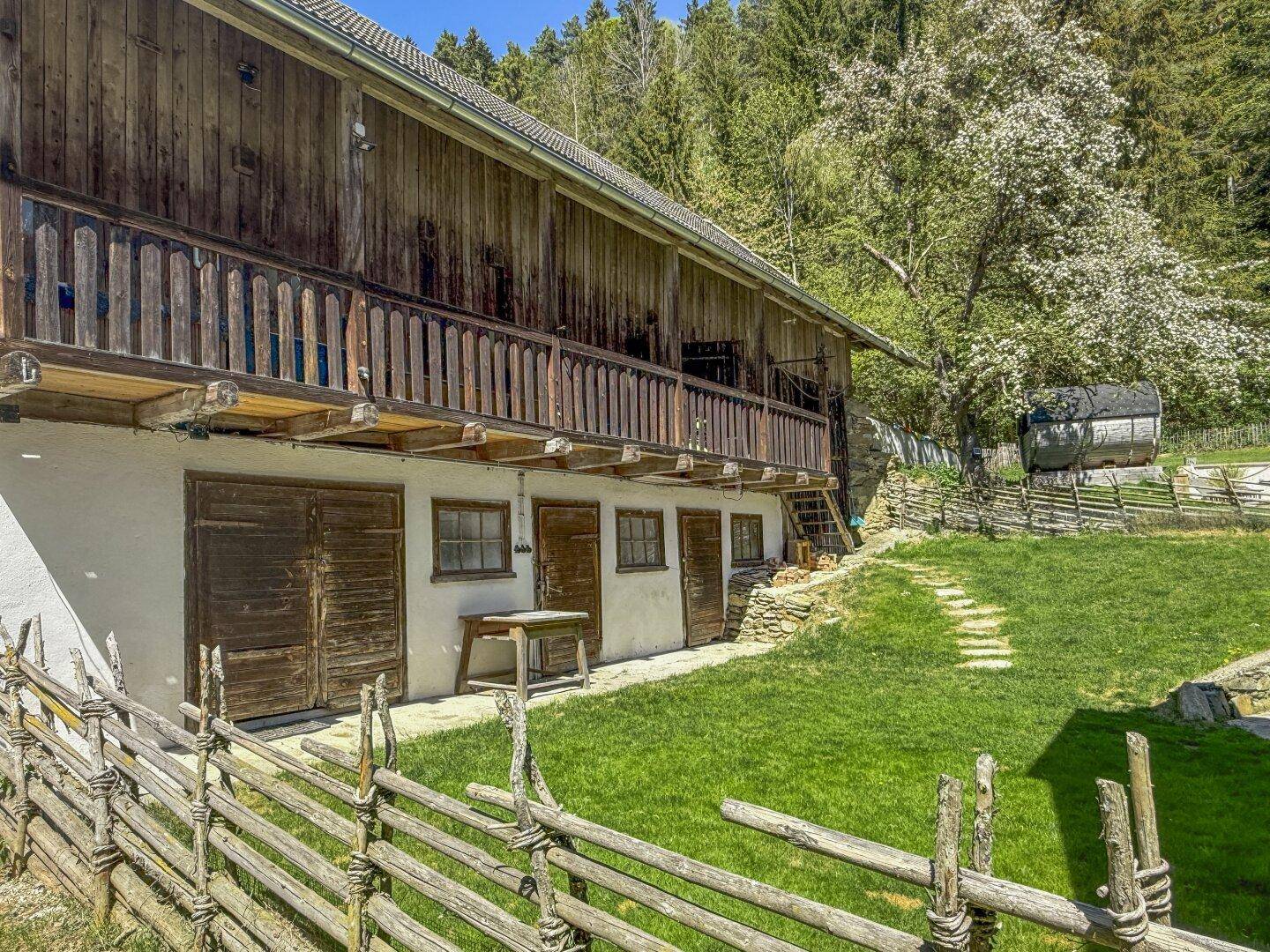 Unterer Bereich eines traditionellen Holzgebäudes mit Balkon und mehreren Holztüren.