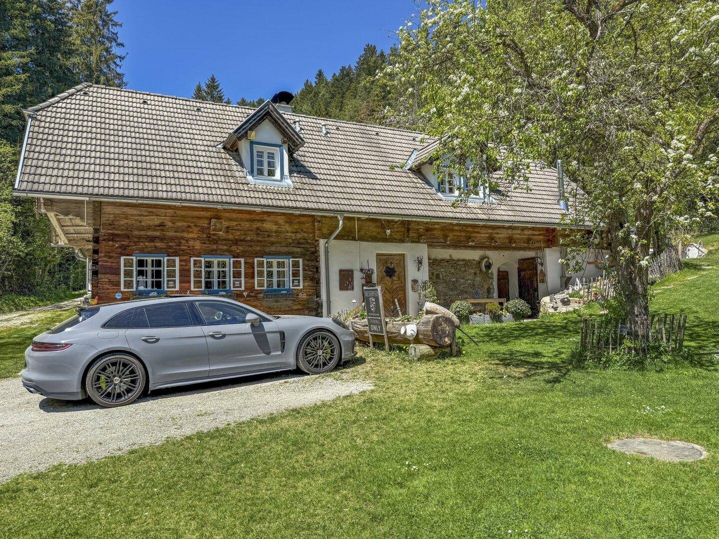 Charmantes Holzhaus mit traditionellem Satteldach und gepflegtem Vorgarten in sonniger Lage.