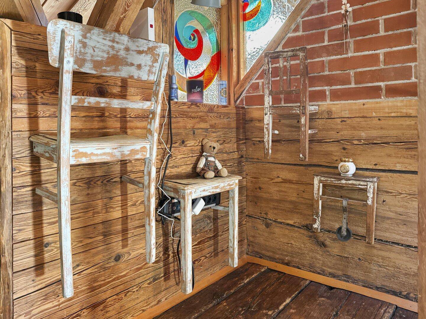 Kreativ gestaltete Ecke im Dachzimmer mit Holzwänden, Ziegelakzenten und einzigartigen Dekorationen.
