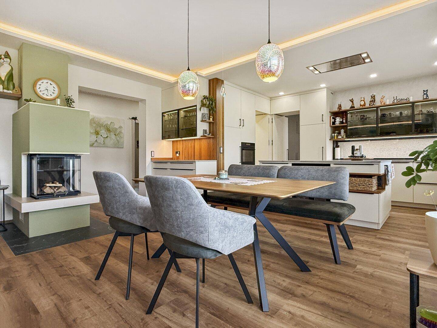 Geräumiger Wohn-Essbereich mit Holzboden, Kamin und moderner Einrichtung für Komfort.