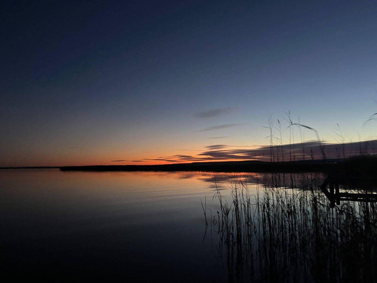 Beeindruckender Sonnenuntergang über dem See, der den Himmel in warme Farben taucht.
