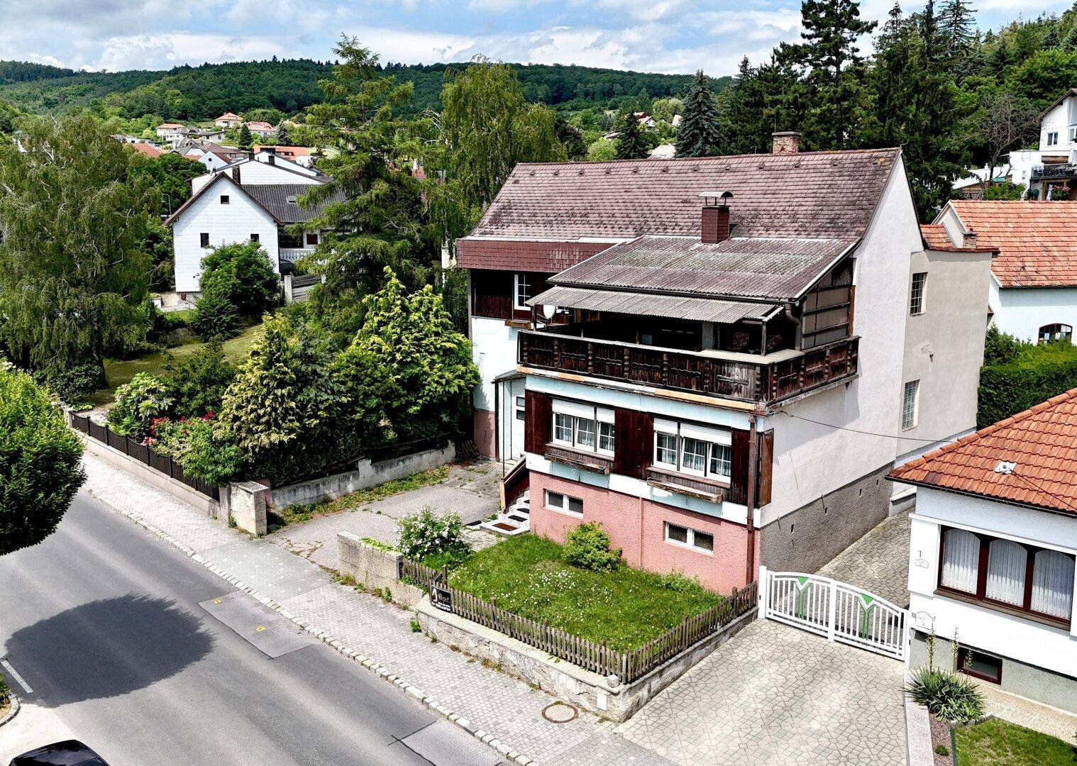 Überblick über das Haus und die Nachbarschaft mit Straße und viel Grün.