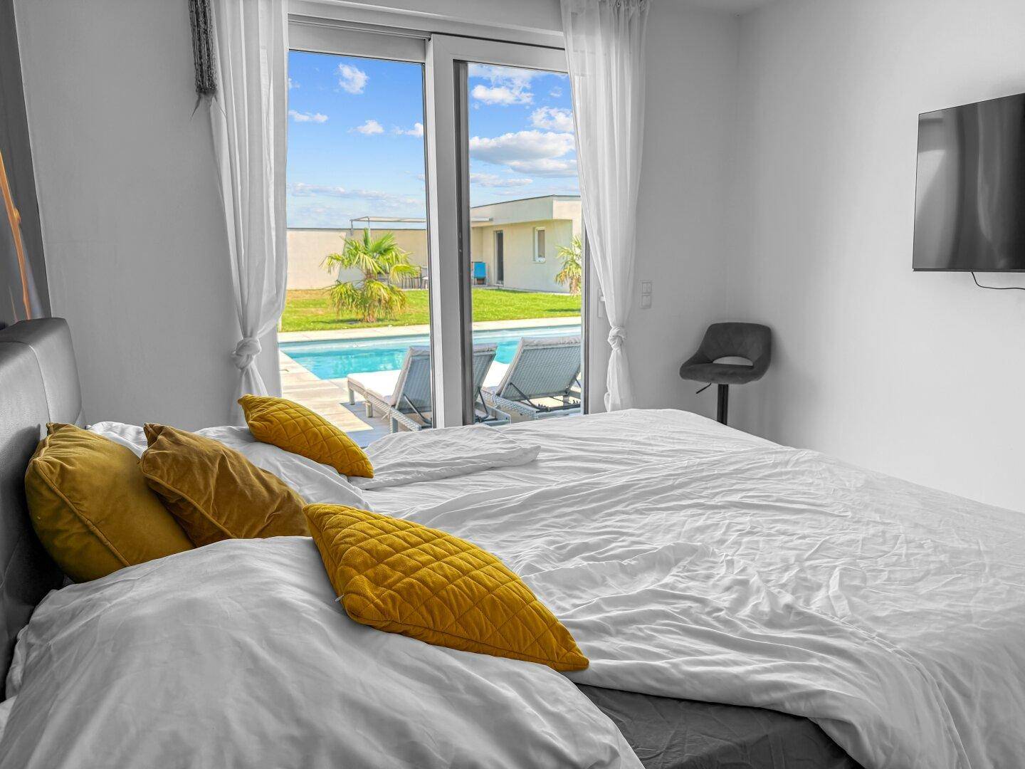 Schlafzimmer mit direktem Blick und Zugang zum privaten Poolbereich im Freien.