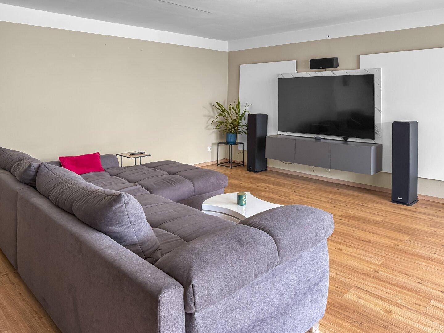 Gemütliches Wohnzimmer mit großem Ecksofa und modernem Entertainment-Bereich.