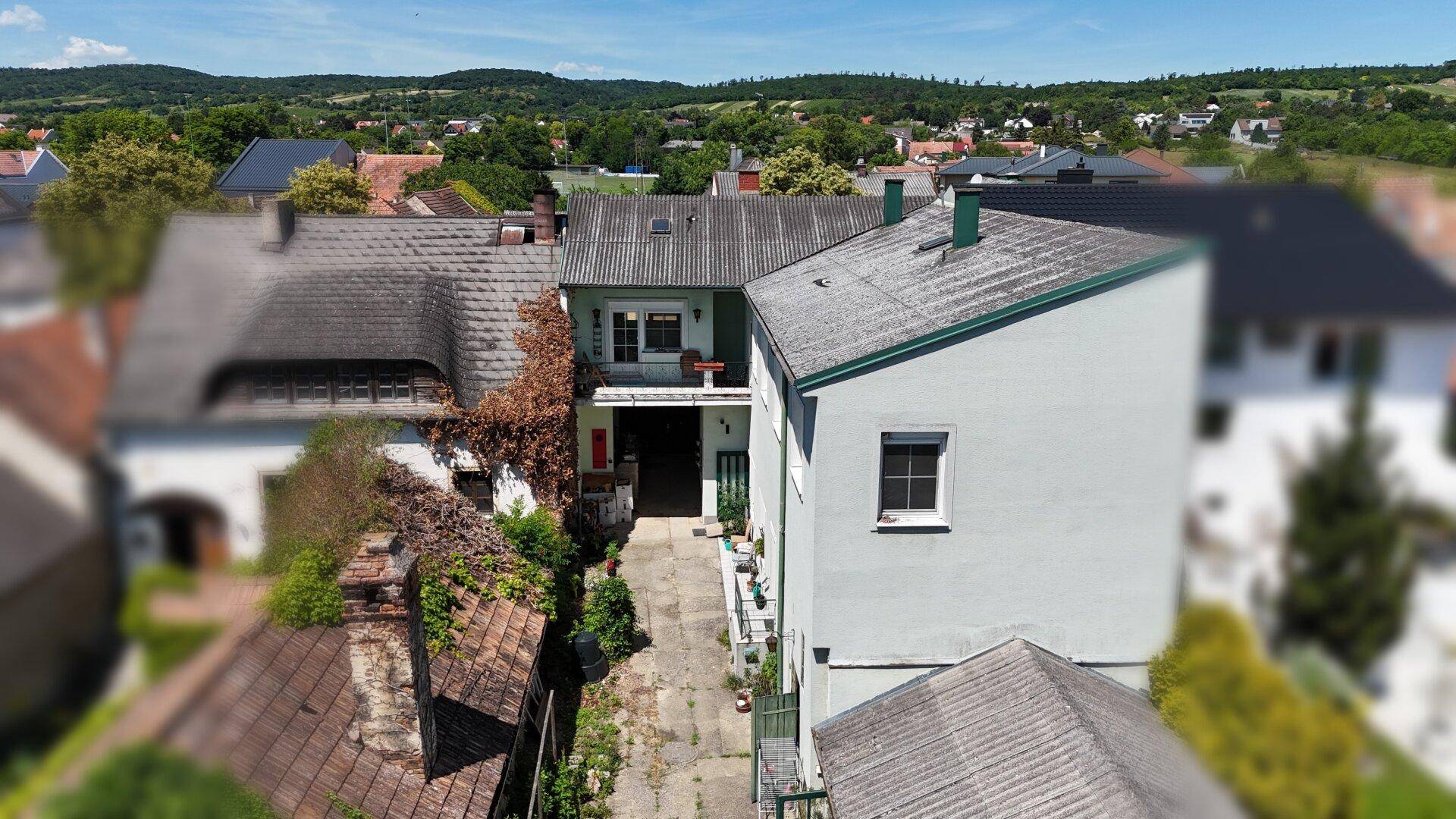 Luftaufnahme des Hauses mit umliegenden Gebäuden und grüner Landschaft.