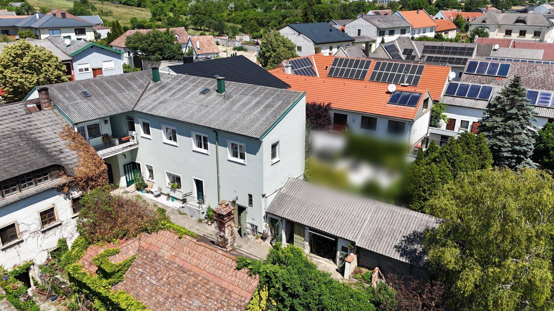Luftaufnahme eines Wohngebiets mit Häusern und Solaranlagen auf den Dächern.