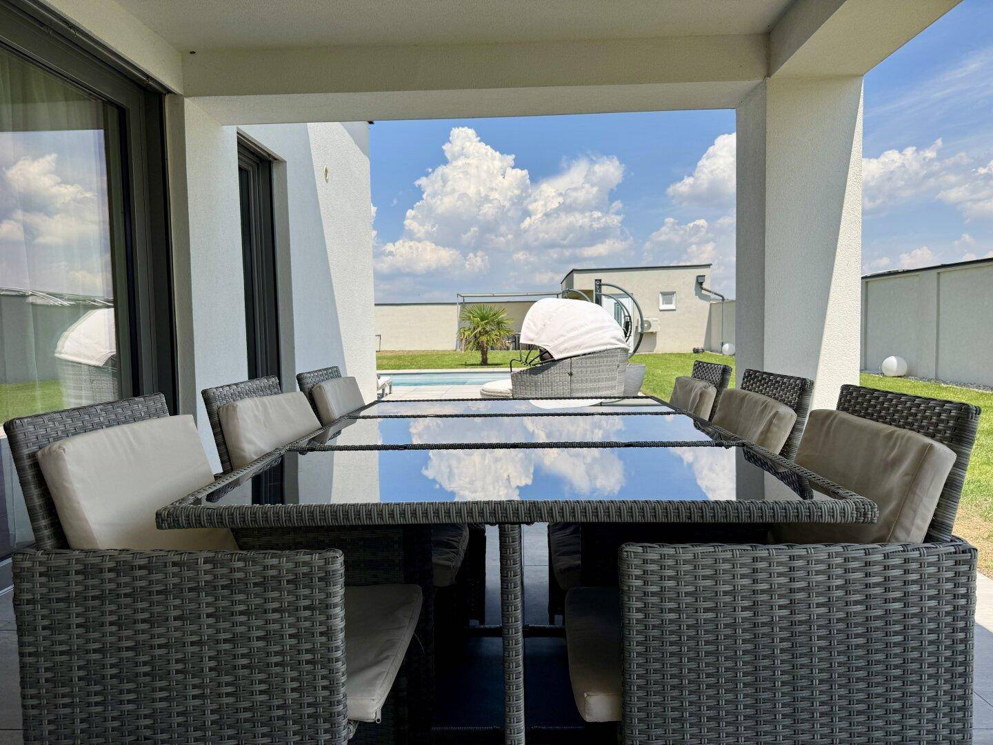 Detailansicht des Esstisches auf der überdachten Terrasse mit Blick auf den Pool.