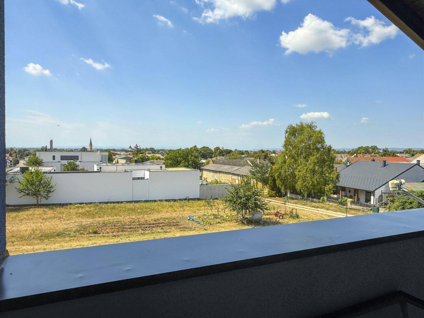 Balkon mit weitem Blick über die ländliche Umgebung und angrenzende Häuser.