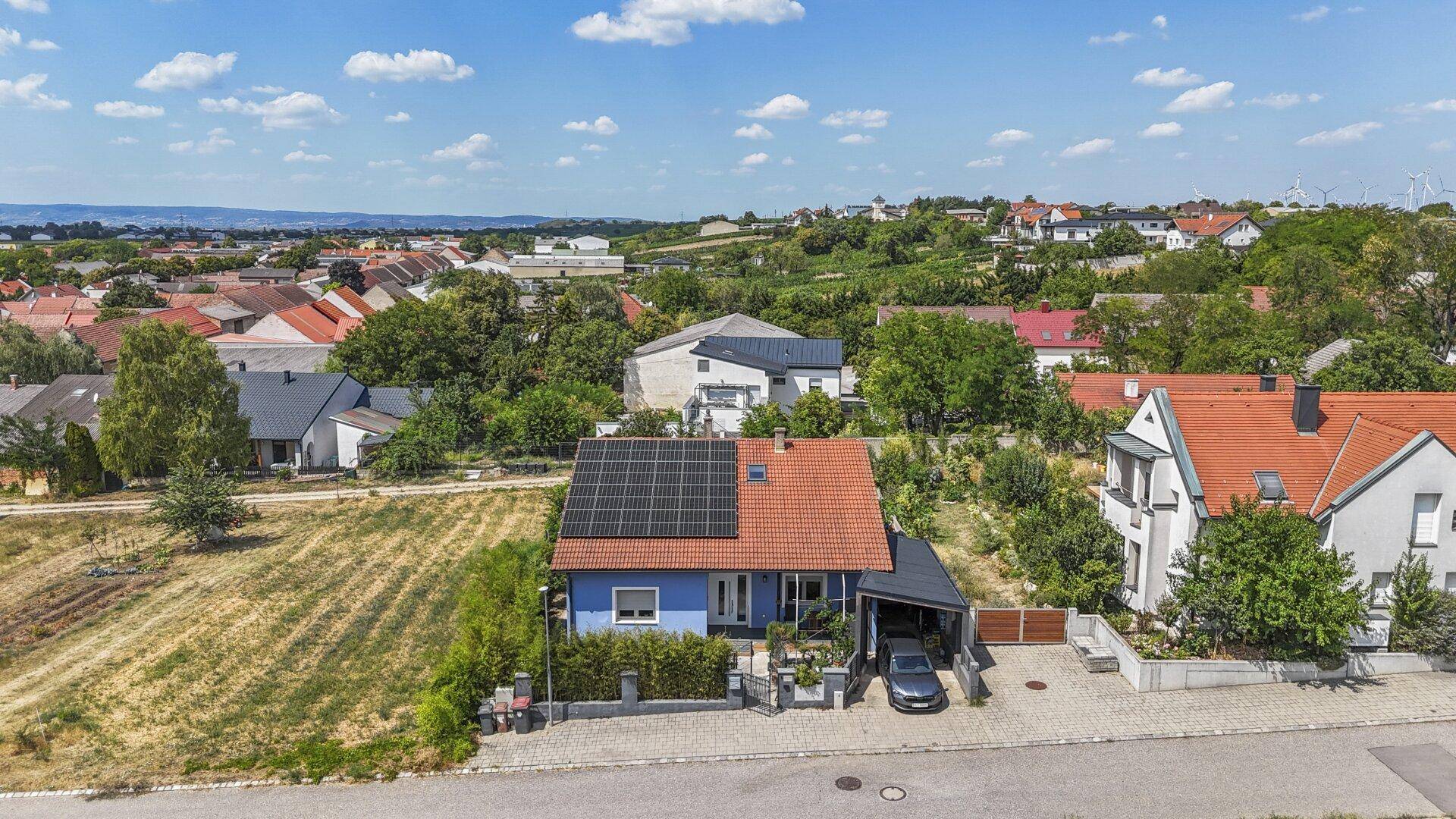 Weitläufige Luftaufnahme des Hauses und der Nachbarschaft mit Feldern und Fernblick.