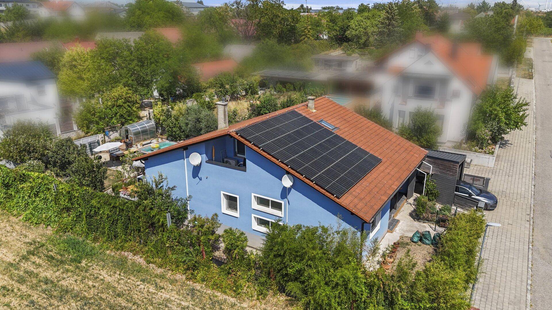 Luftaufnahme von der Rückseite des Hauses mit Poolbereich und Solaranlage auf dem Dach.