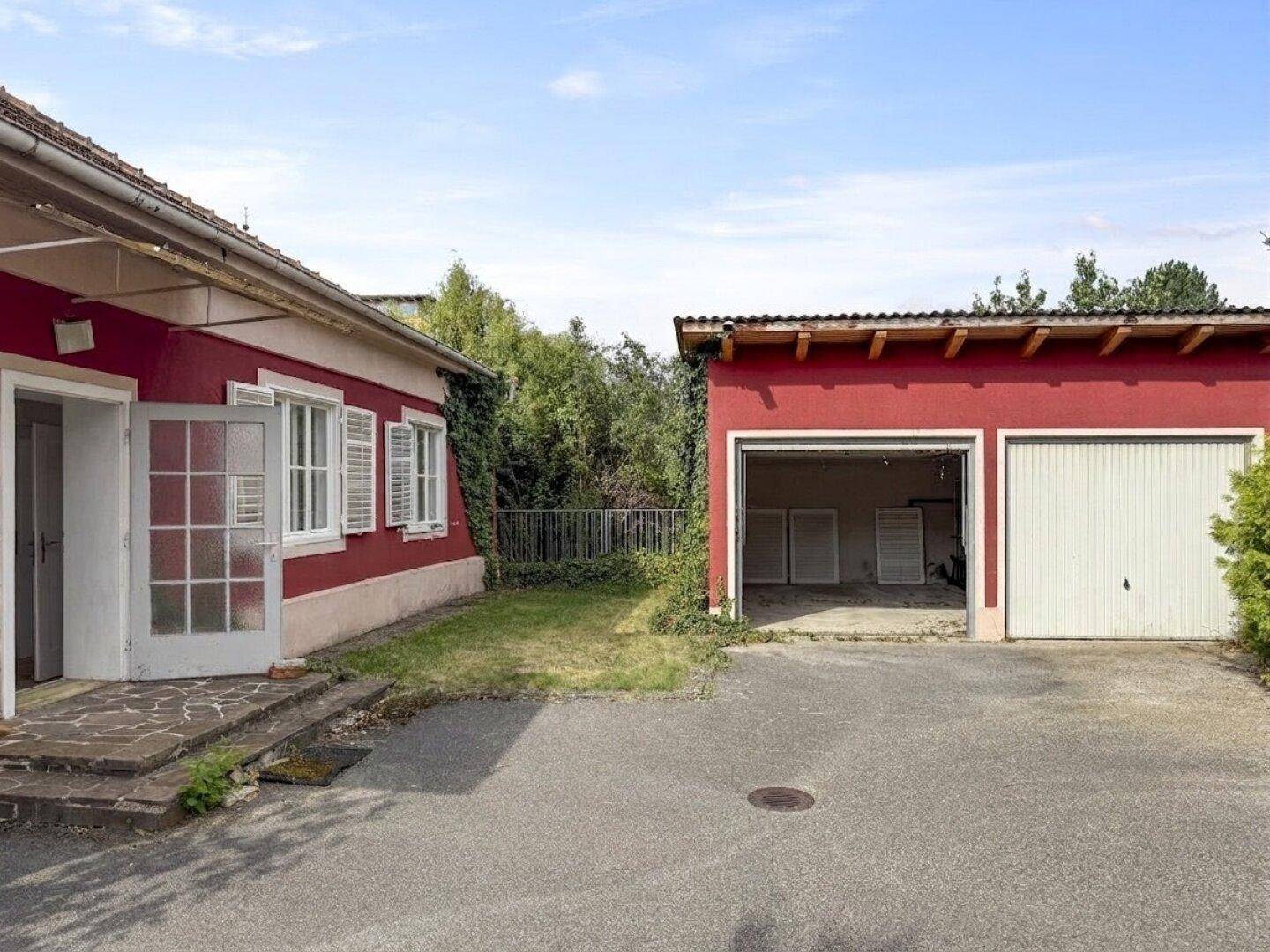 Außenansicht des hinteren Hauseingangs und der Doppelgarage mit Zufahrt.