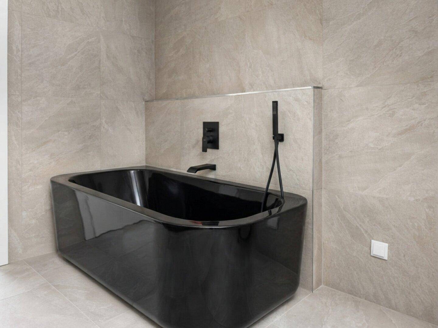 Elegante schwarze Badewanne mit passender Armatur in einem modern gefliesten Badezimmer.
