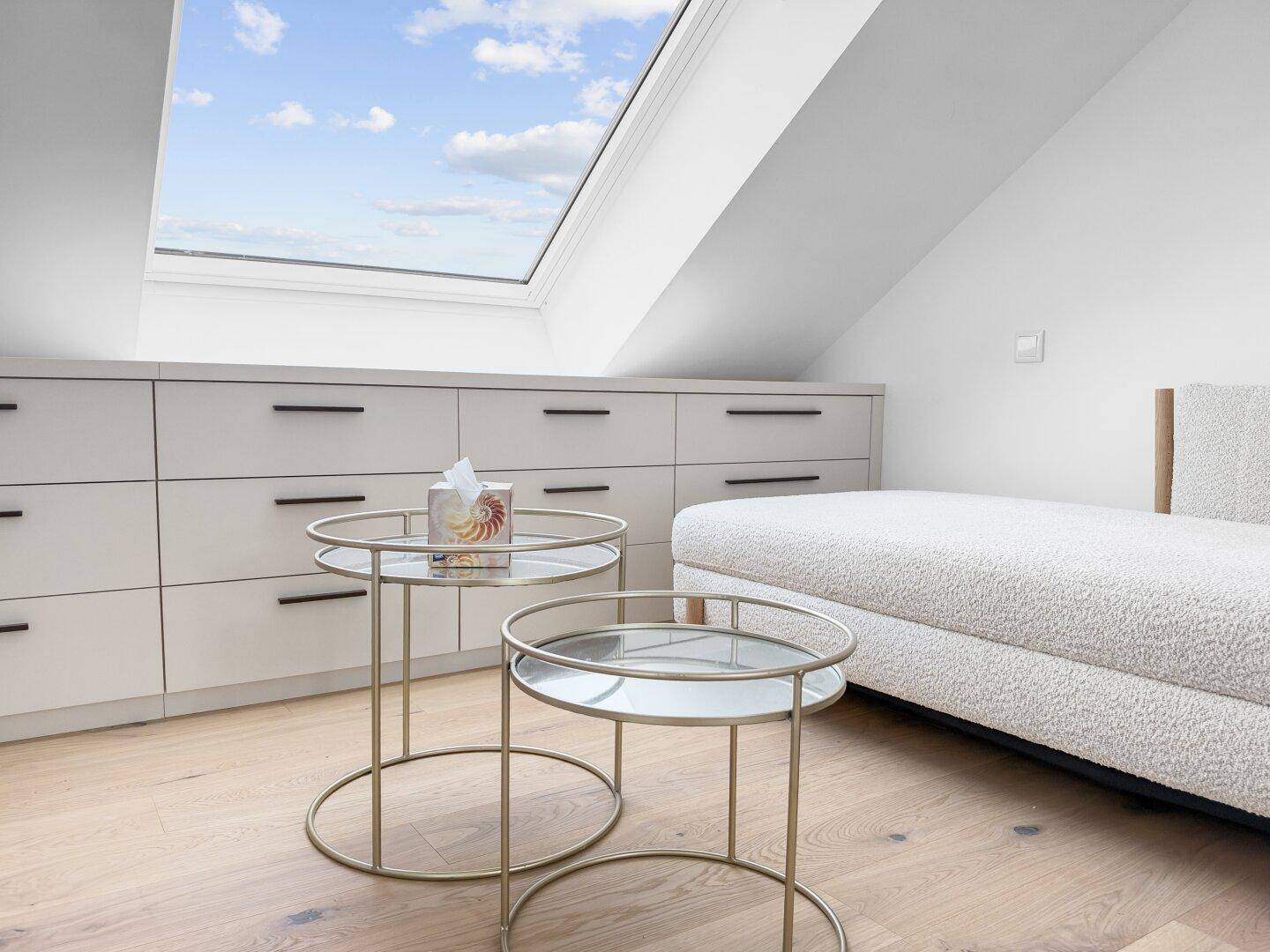 Detailansicht des Tagesbetts und der Einbauschränke unter dem großen Dachfenster im Dachgeschoss.