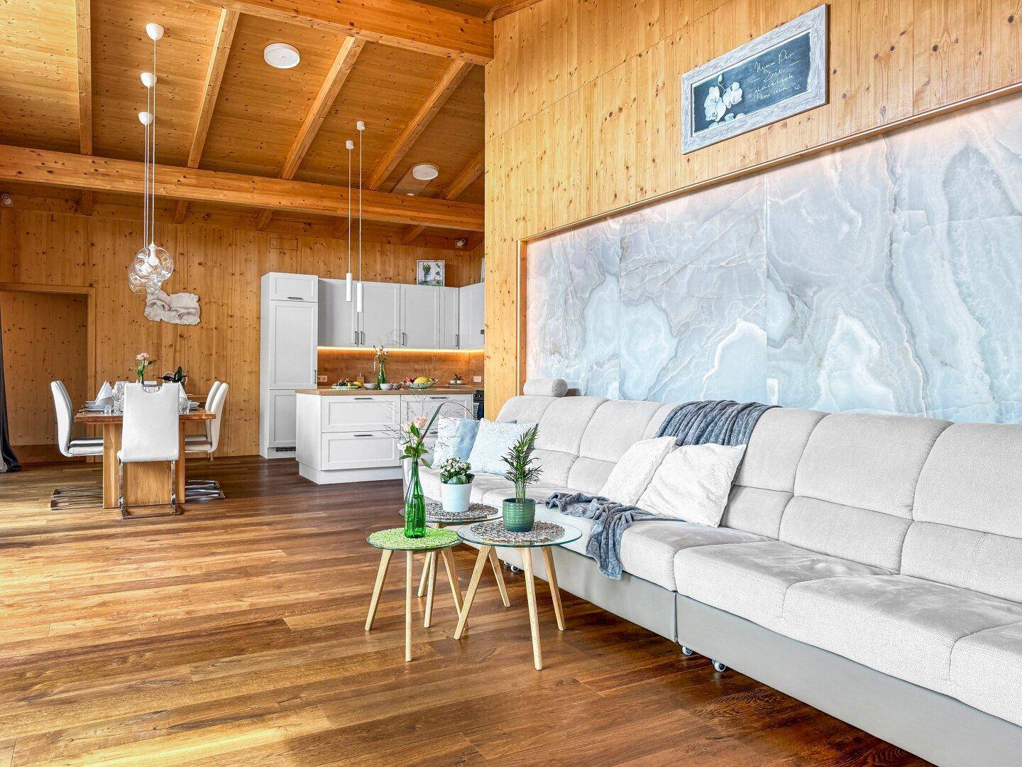Offener Wohn- und Essbereich mit integrierter moderner Küche und Holzboden.