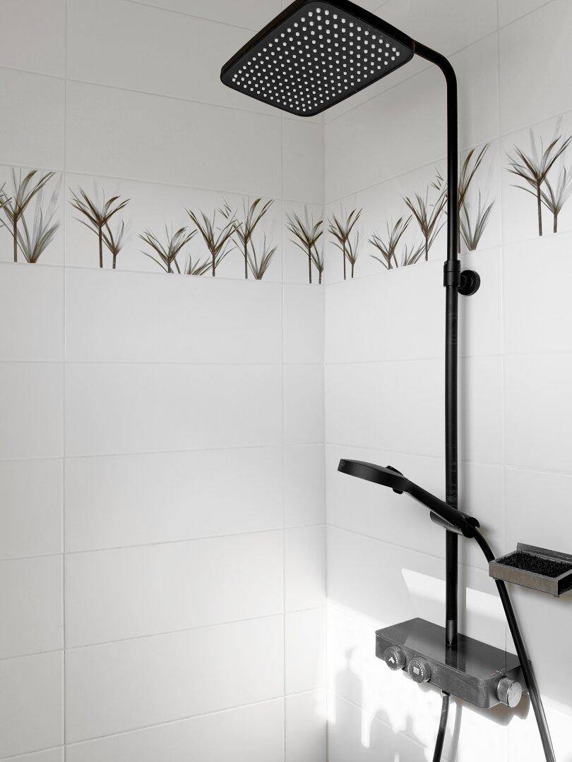 Moderne Dusche mit Regenduschkopf und weißen Fliesen, minimalistisch gestaltet.