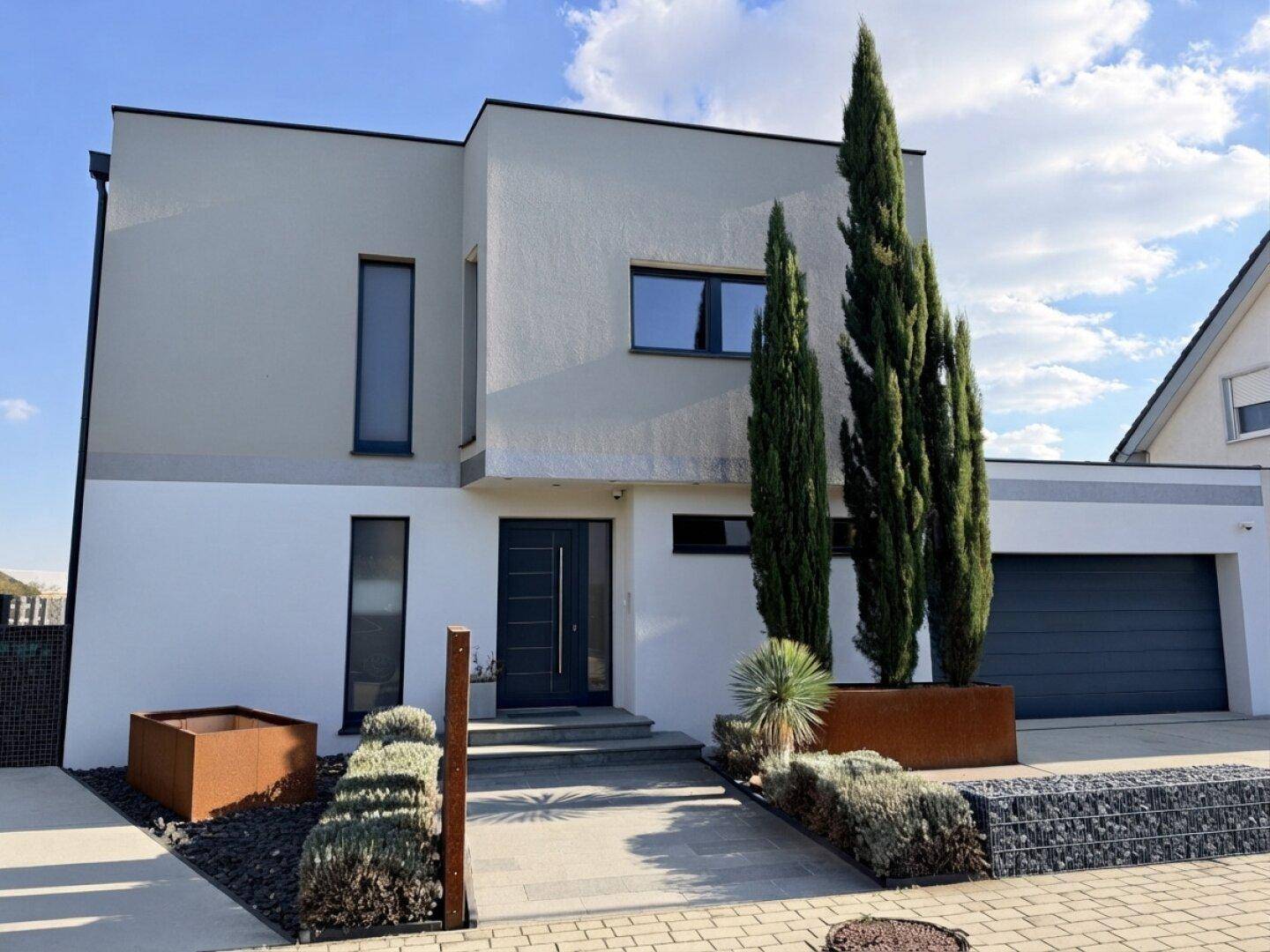 Moderne Hausfassade mit klaren Linien, großem Eingangsbereich und integrierter Garage.