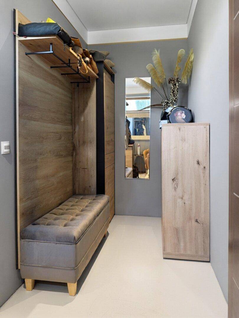 Heller Flur mit Garderobe, Sitzbank und Holzvertäfelung für eine einladende Atmosphäre.