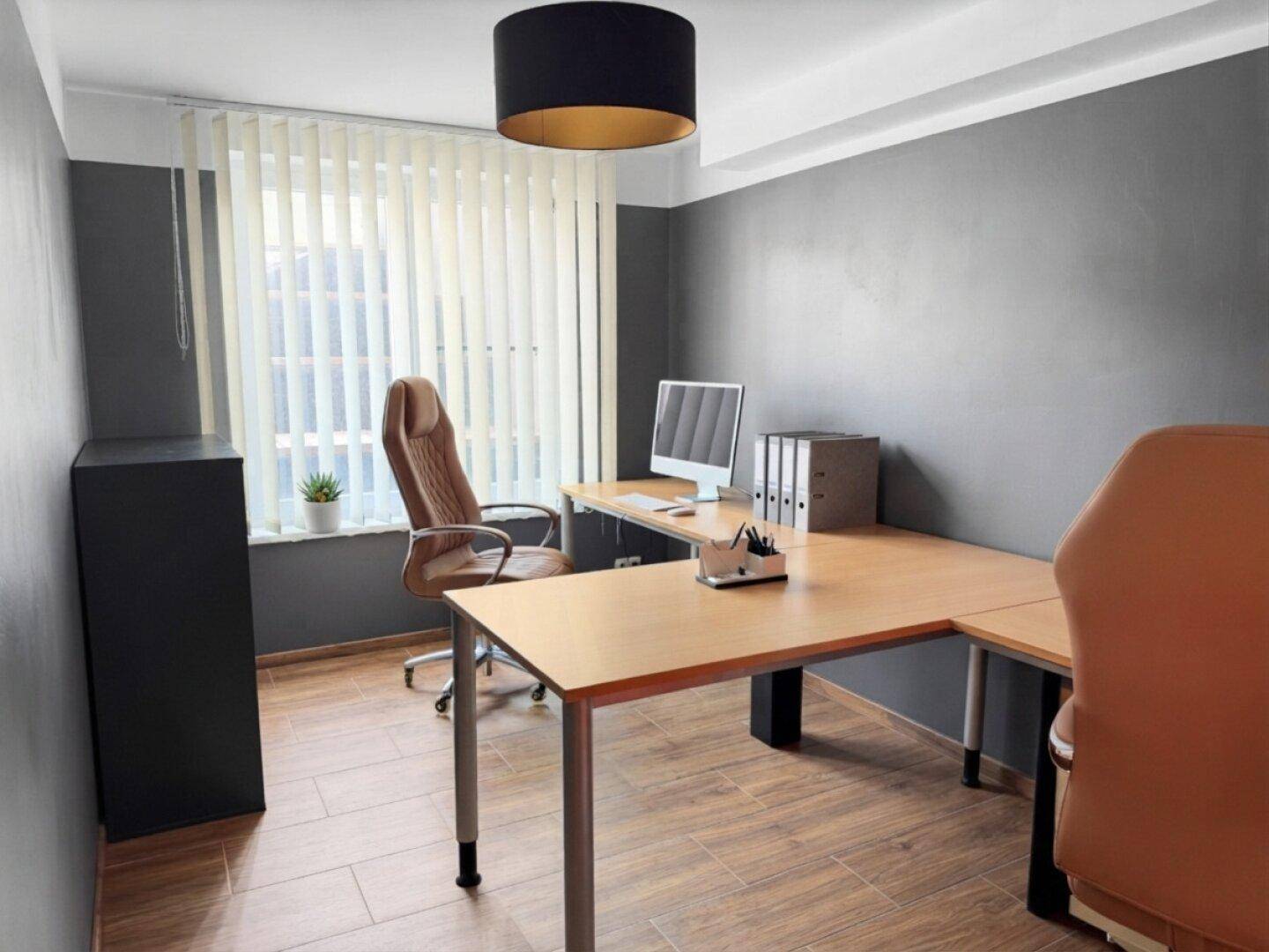 Funktionales Büro mit Schreibtisch, Bürostuhl und Fenster mit Jalousien für konzentriertes Arbeiten.
