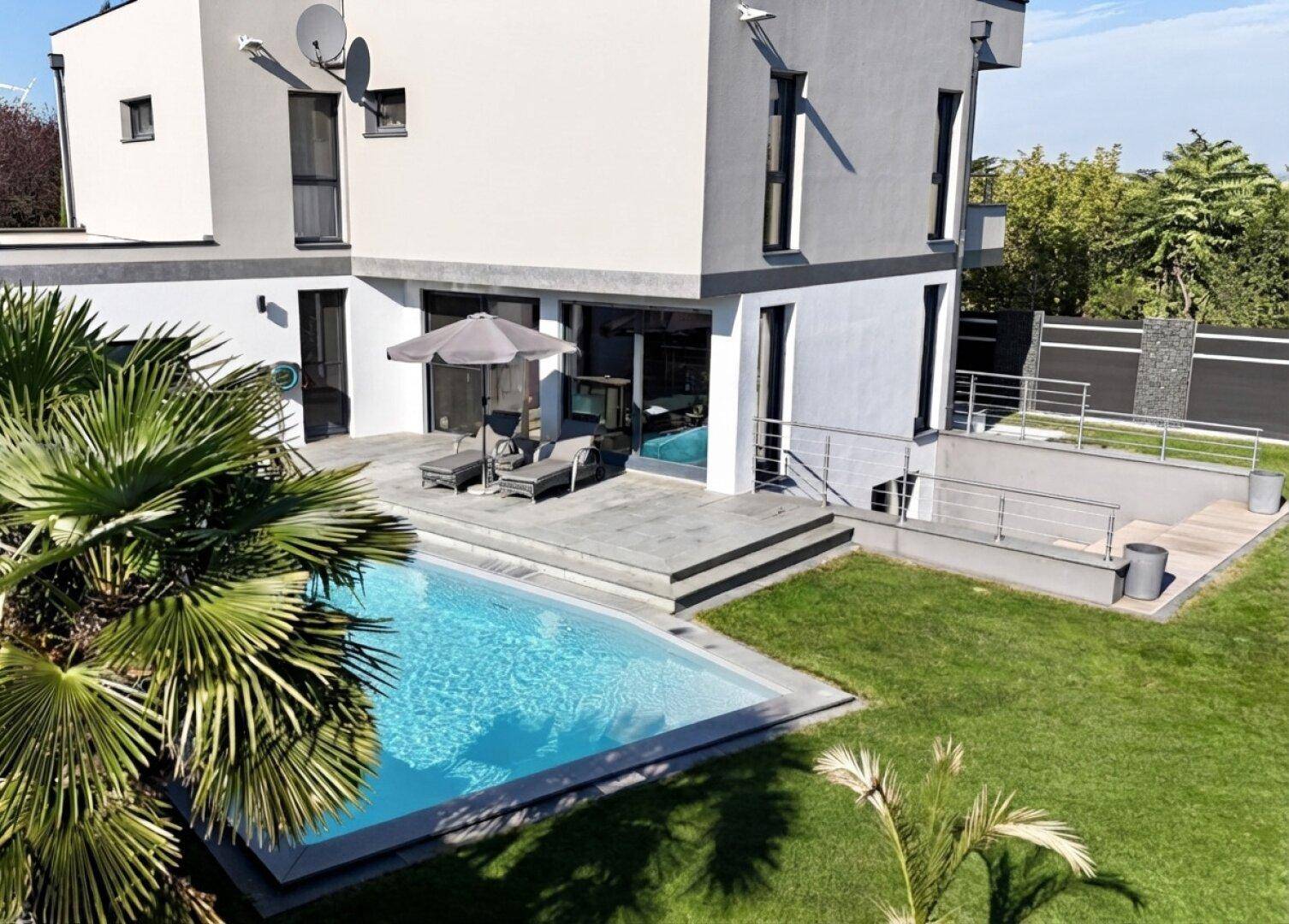Moderner Garten mit Pool, Liegefläche und Treppenabgang zum Untergeschoss.