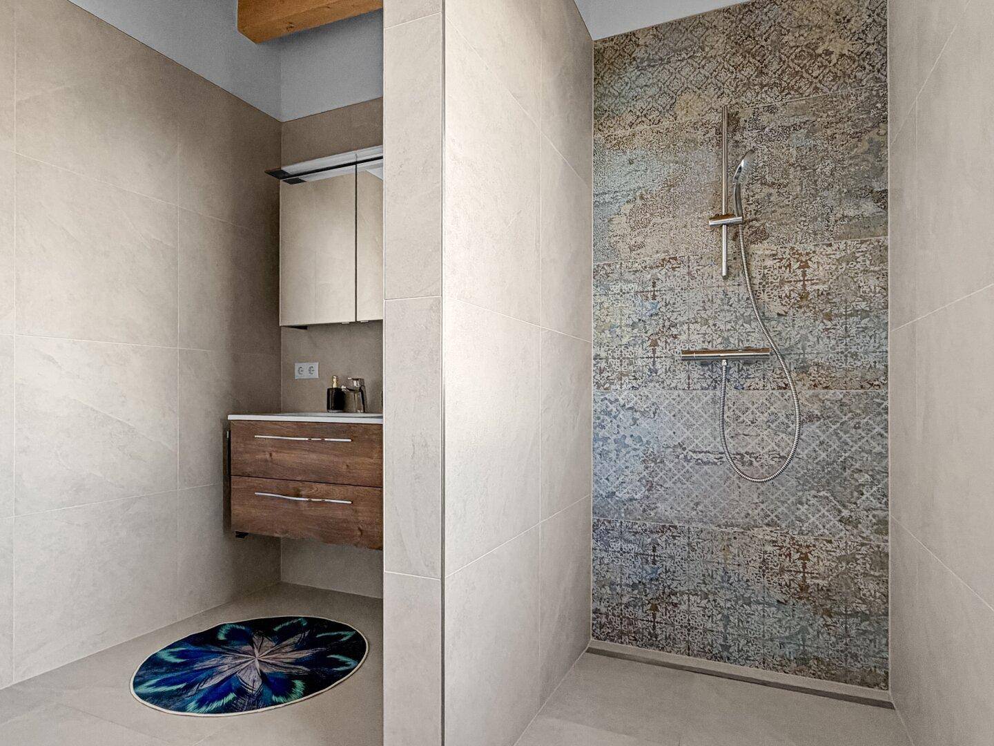 Modernes Badezimmer mit ebenerdiger Dusche und stilvollen Fliesen.