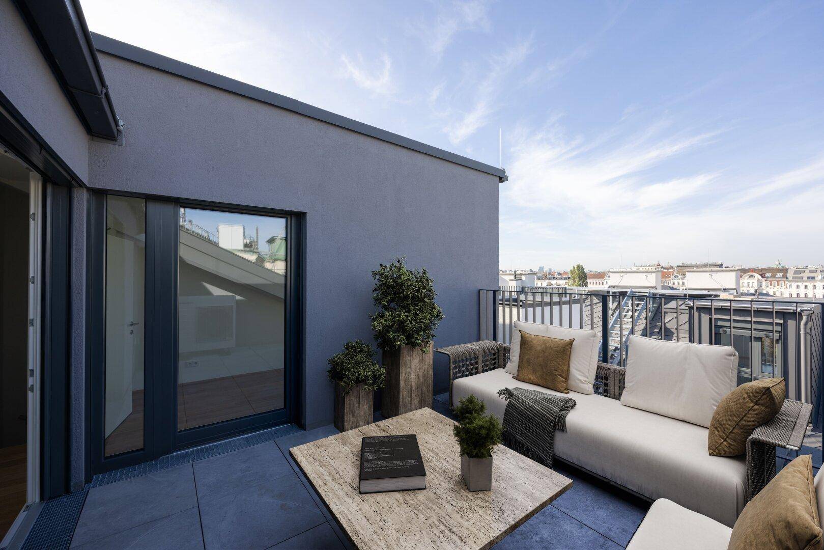 Möblierte Dachterrasse mit bequemen Sitzgelegenheiten und weitem Blick über die Stadt.