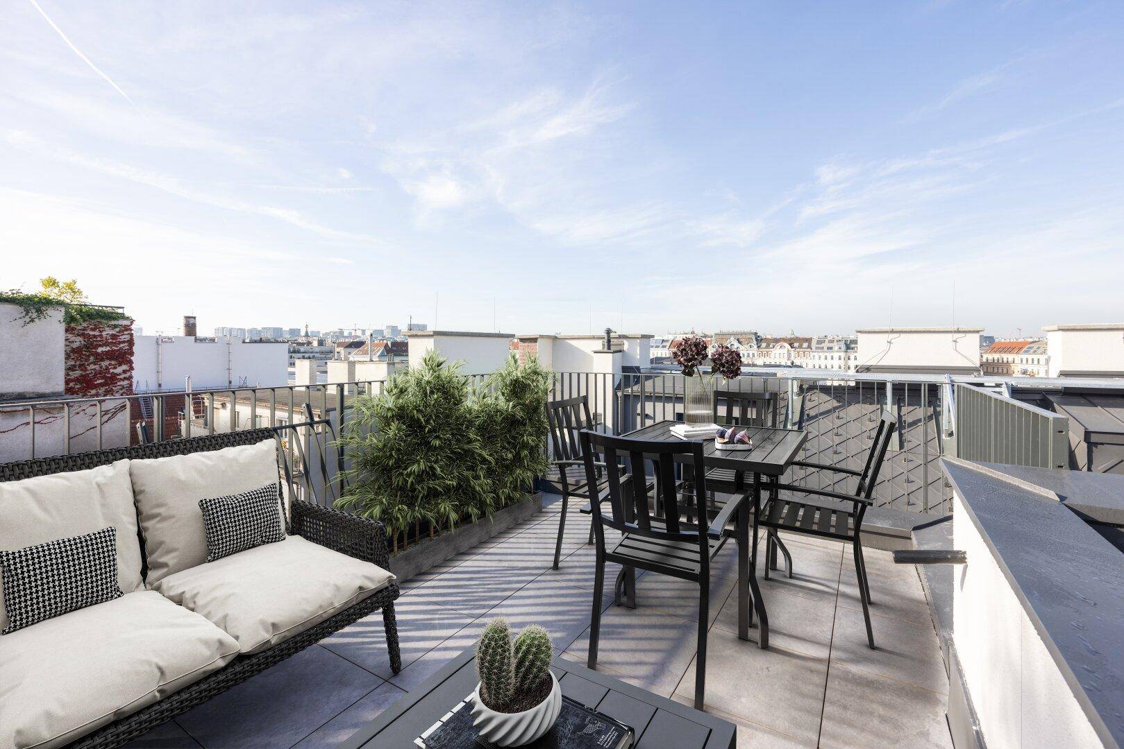 Geräumige Dachterrasse mit Sitzgelegenheiten und weitem Blick über die Dächer der Stadt.