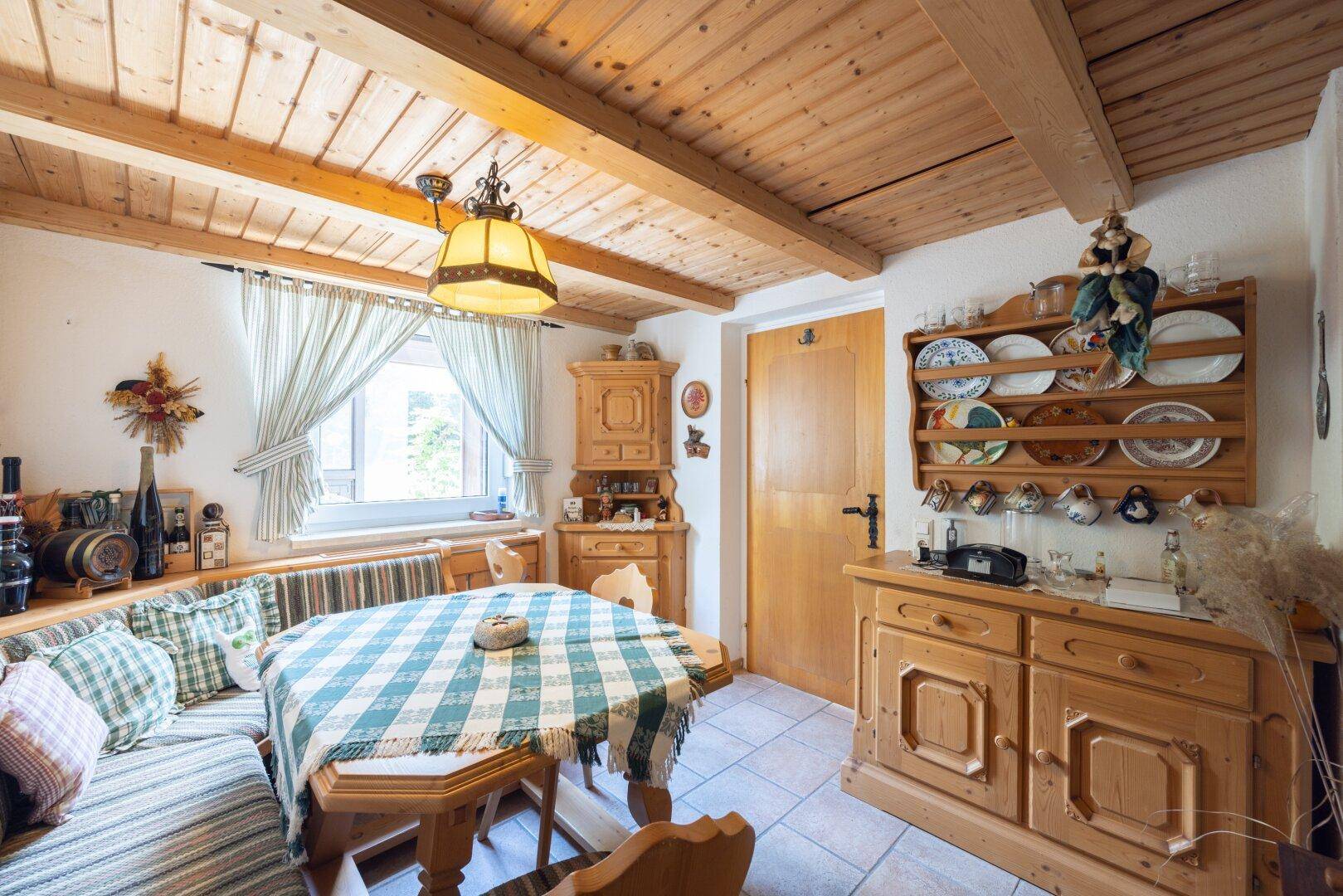 Traditioneller Essbereich mit rustikalen Holzmöbeln, Holzdecke und gefliestem Boden.