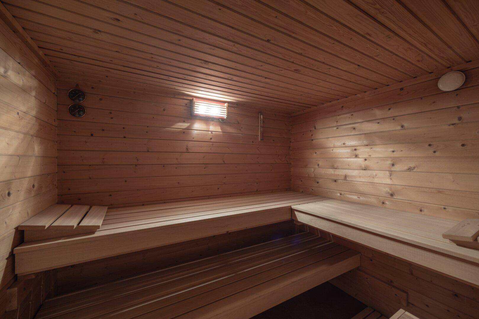 Gemütliche Holzsauna mit mehreren Sitzebenen, ideal zur Entspannung.