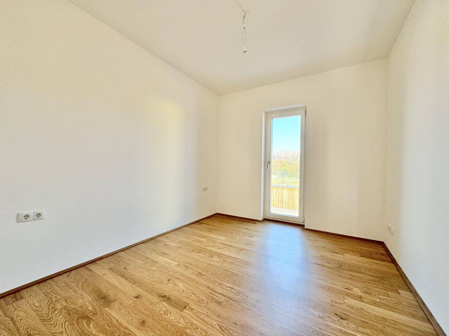 Helles Zimmer mit Eichenparkett und Zugang zu einem französischen Balkon, ideal als Schlaf- oder Arbeitszimmer.