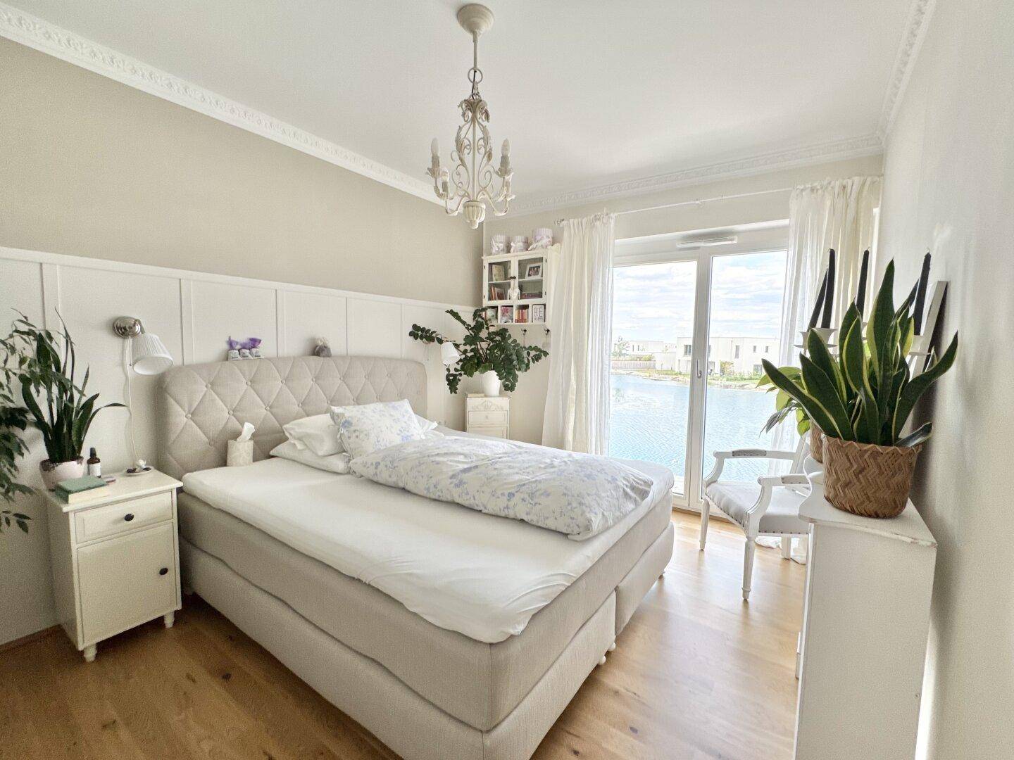 Gemütliches Schlafzimmer mit Doppelbett, Stuckdecke und direktem Seeblick.