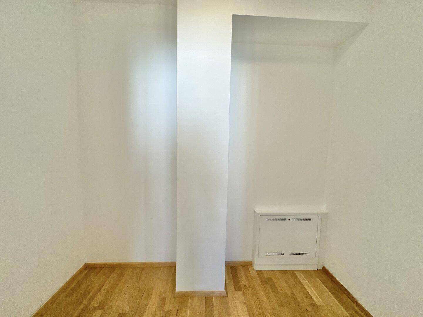 Kleiner Raum mit Parkettboden und weißem Wandschrank, ideal als Abstellfläche nutzbar.