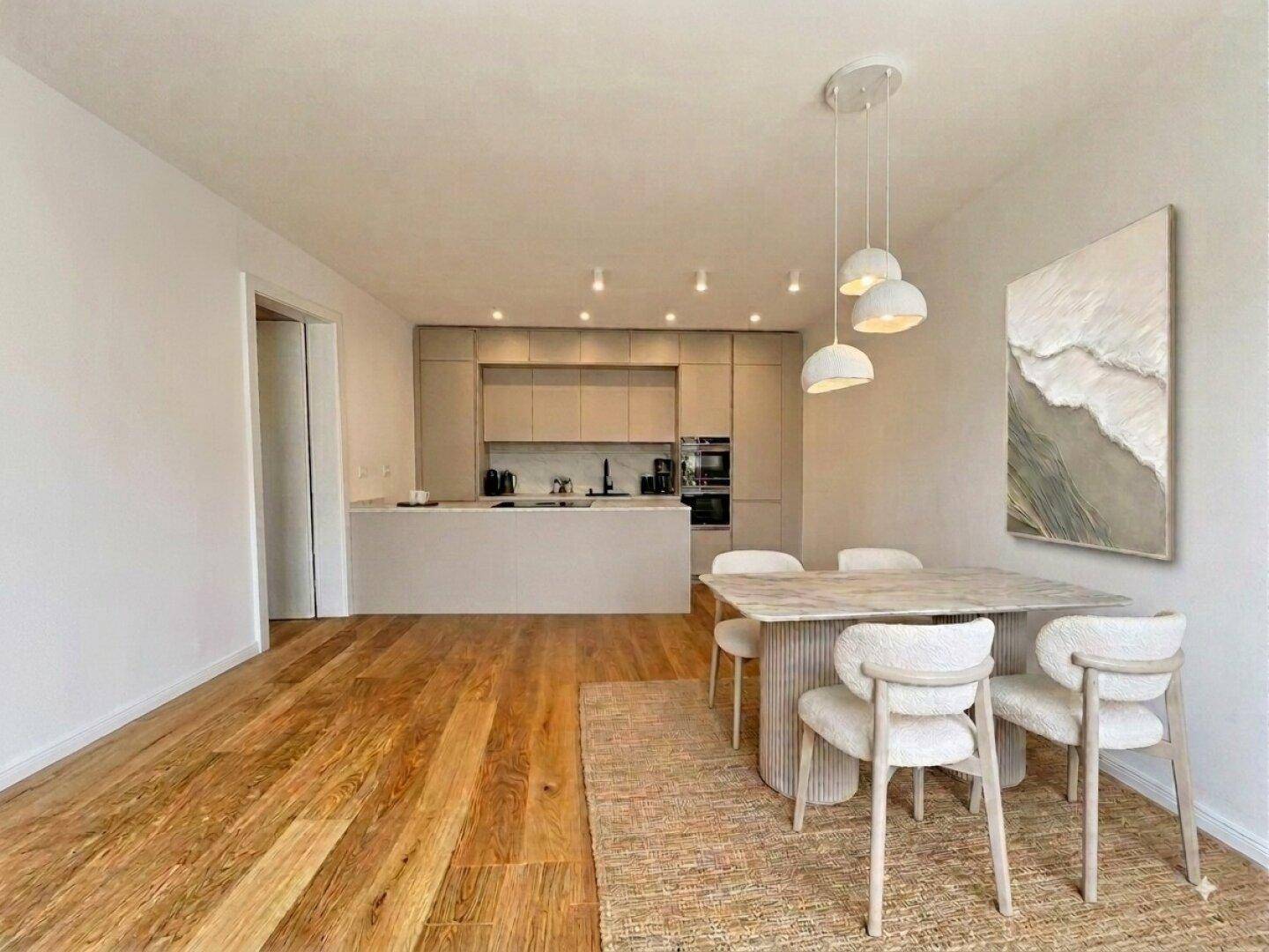 Moderne offene Küche mit Essbereich, Holzboden und hochwertigen Einbaugeräten.