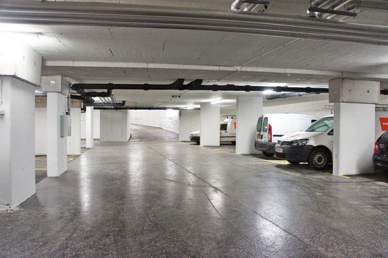 Tiefgarage mit mehreren Stellplätzen und Betonpfeilern.