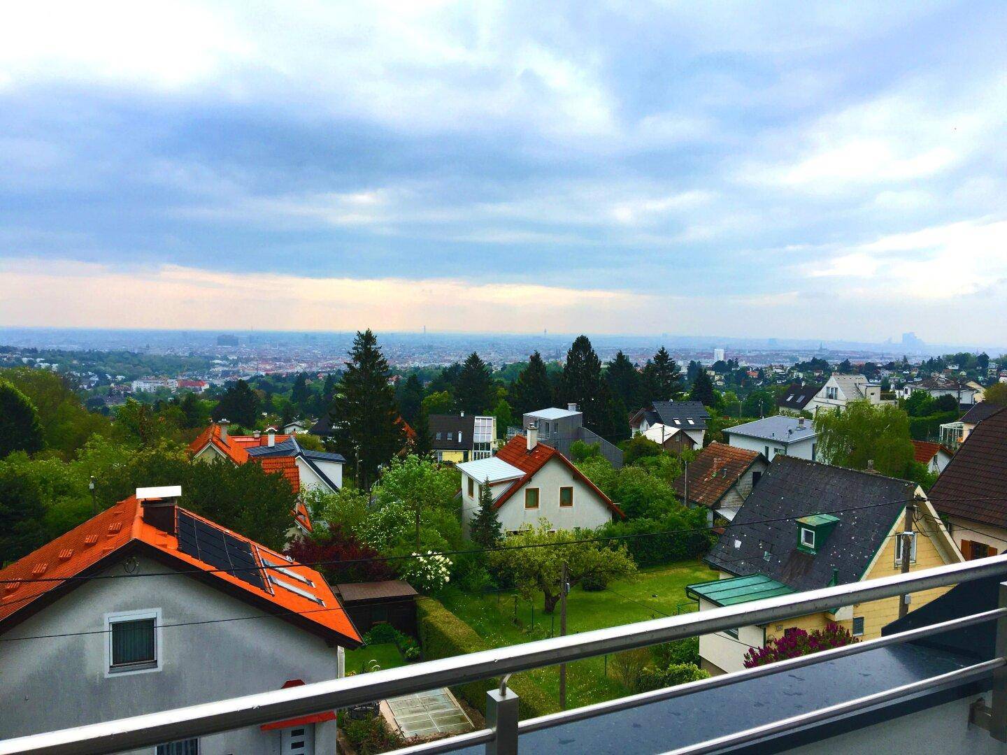 Weitläufiger Blick über die Dächer der Stadt und die umliegende grüne Landschaft.