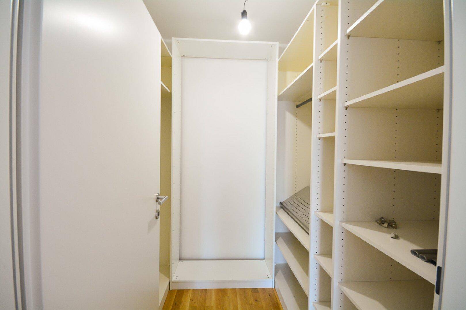 Praktischer begehbarer Kleiderschrank mit vielen Regalen und Stauraum.