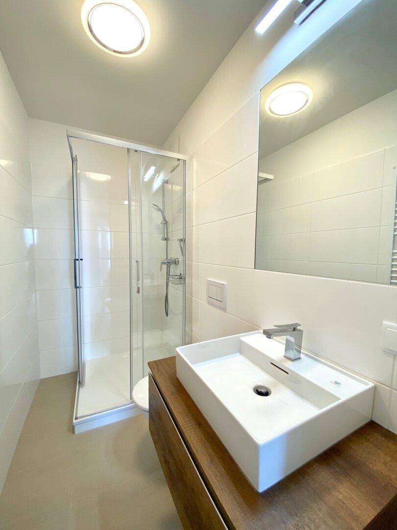 Modernes Badezimmer mit Duschkabine, Einzelwaschbecken und Wand-WC.