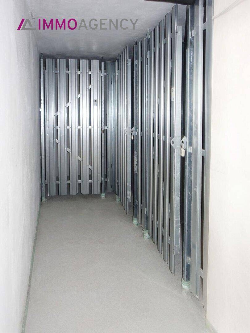 Praktischer Abstellraum im Keller mit Metallabtrennungen für sichere Lagerung von persönlichen Gegenständen.