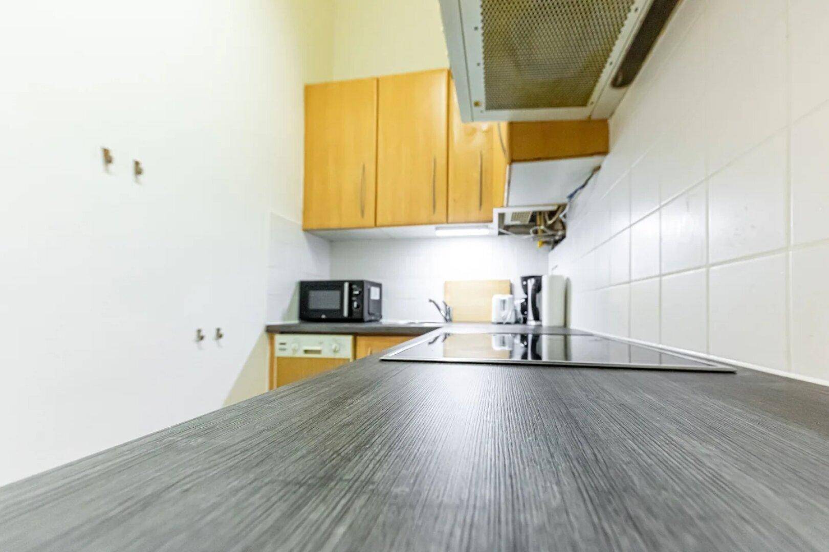 Küchenarbeitsplatte aus Holz mit integriertem Kochfeld und Mikrowelle.