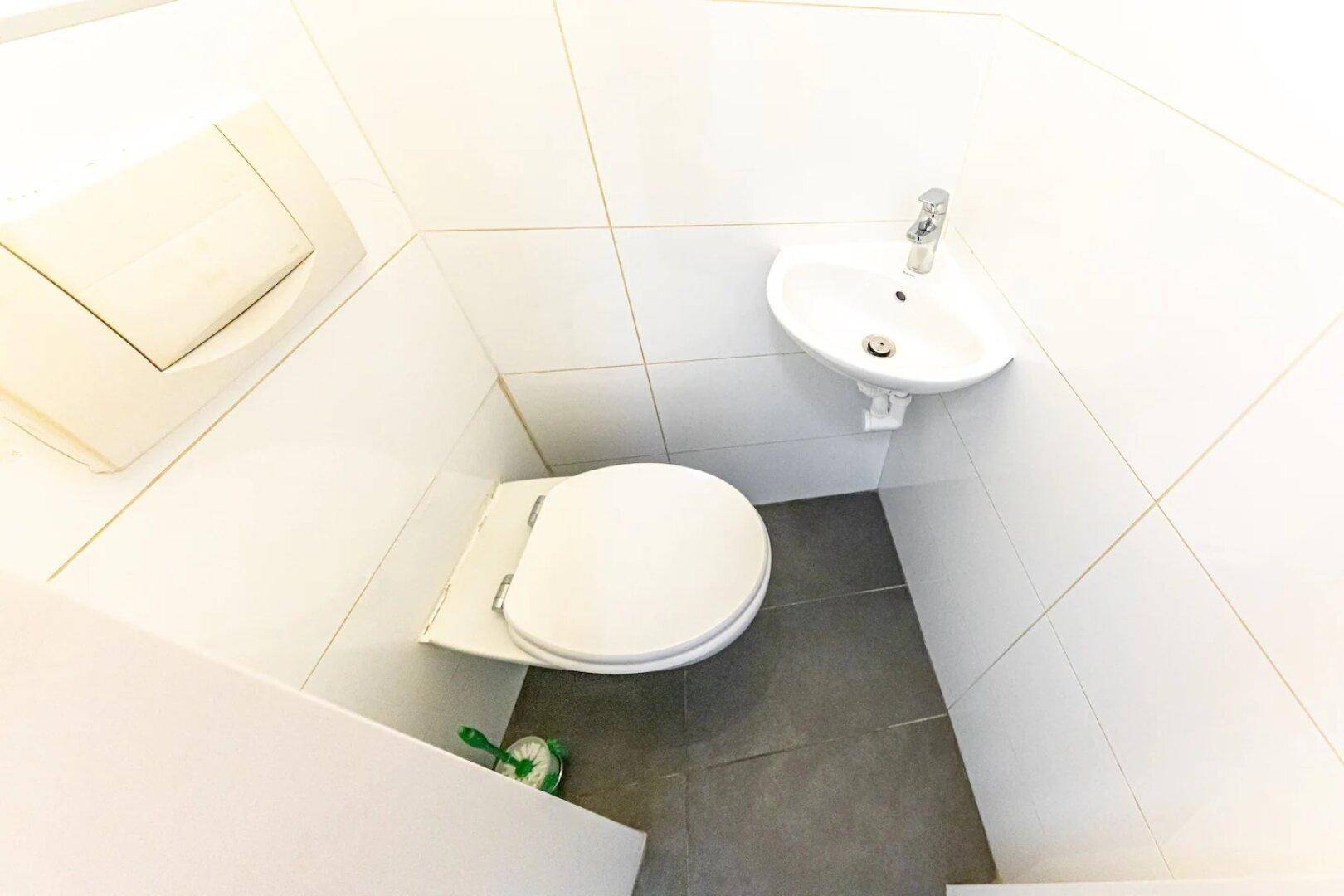 Separate Gästetoilette mit WC und kleinem Handwaschbecken.