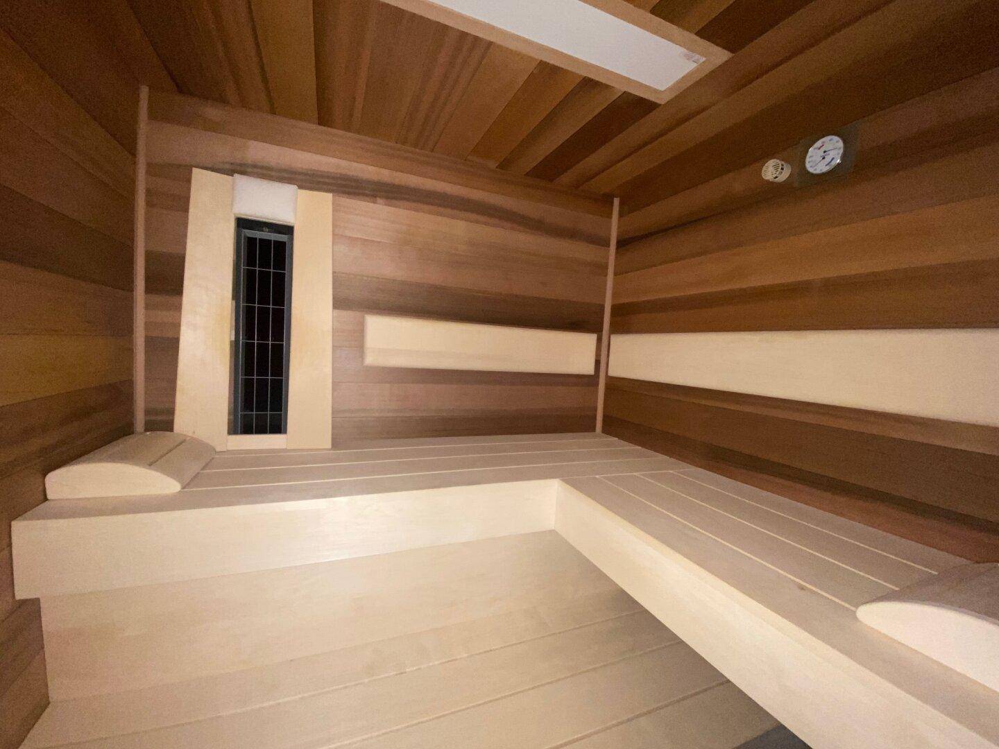 Gemütliche Holzsauna mit Bänken und integriertem Ofen für entspannende Momente.
