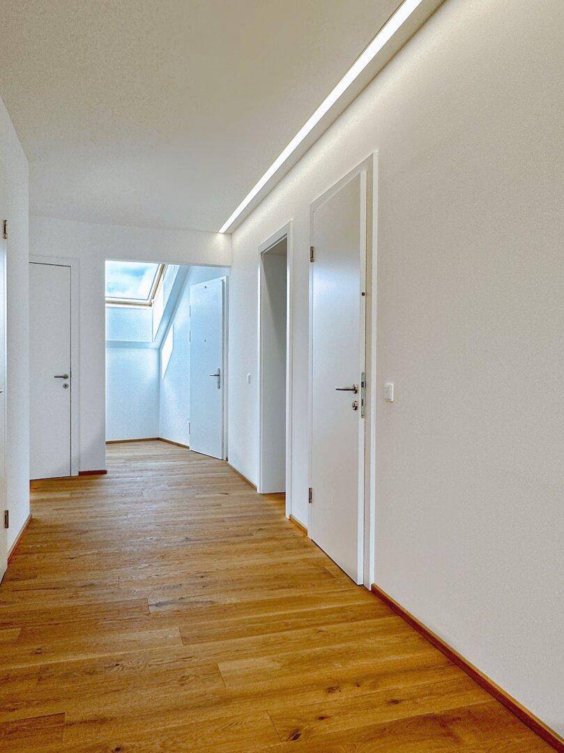 Langer Flur mit Eichenparkett und Oberlicht, das für zusätzliche Helligkeit sorgt.
