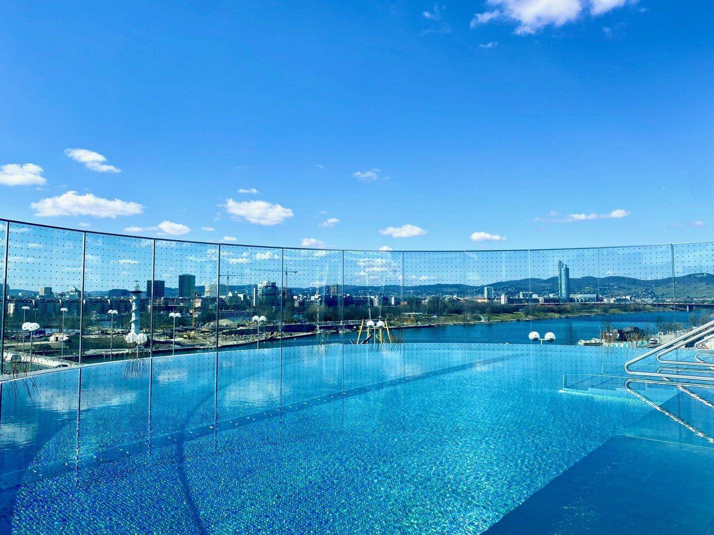 Dachterrasse mit Infinity-Pool und atemberaubendem Panoramablick auf die Stadt und den Fluss.